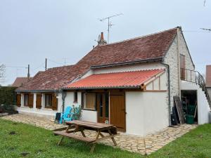 een huis met een picknicktafel ervoor bij Charmante maison berrichonne in Gargilesse-Dampierre