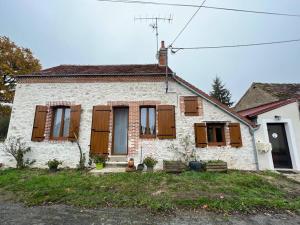 a white house with wooden shutters on the windows at Charmante maison berrichonne in Gargilesse-Dampierre +3 photos