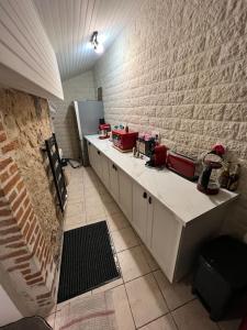a kitchen with a counter and a brick wall at Charmante maison berrichonne in Gargilesse-Dampierre