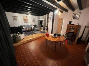 ein Wohnzimmer mit einem Tisch und einem Sofa in der Unterkunft Charmante maison berrichonne in Gargilesse-Dampierre