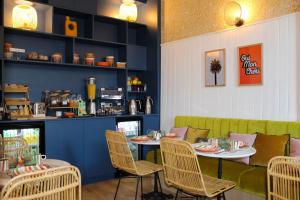 a dining room with a table and chairs and a counter at Aparthotel AMMI Nice Massena in Nice