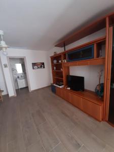 a living room with a flat screen tv and a large entertainment center at Casa Incanto Marina Bis in Marina di Ragusa