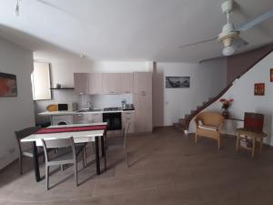 a kitchen and living room with a table and chairs at Casa Incanto Marina Bis in Marina di Ragusa
