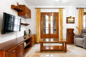 a living room with a tv and a coffee table at Casa Lola Centro de Nerja in Nerja