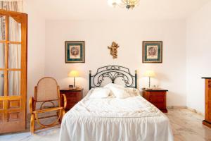 a bedroom with a bed and two tables and a chair at Casa Lola Centro de Nerja in Nerja