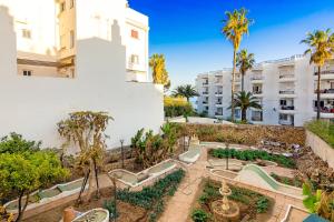 a view of the courtyard of a building with palm trees at Casa Lola Centro de Nerja in Nerja