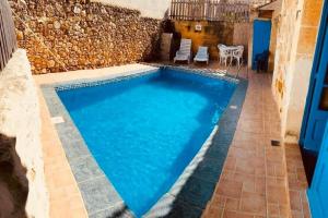 una piscina en medio de un patio en Tan-Nahla (128B) Holiday Farmhouse with Private Pool en Il-Pergla