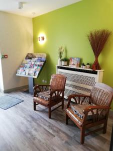 um quarto com duas cadeiras e uma mesa com livros em Hotel du Commerce em Cholet