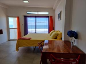 a bedroom with a bed and a table and a window at Hotel Ola Bella in San Clemente