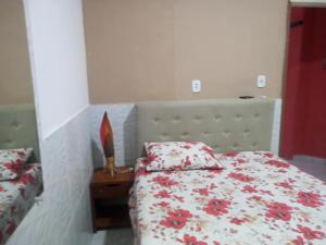 a bedroom with a bed with red flowers on it at Cantinho Nativus in Maragogi