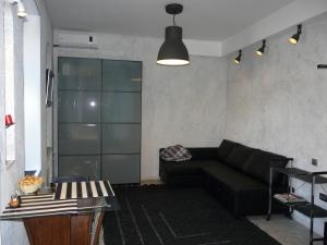sala de estar con sofá negro y mesa en Modern Apartments, en Peterhof