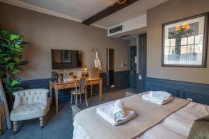 a bedroom with two beds and a desk and a television at Salisbury Arms Hotel in Hertford