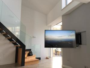 a flat screen tv hanging on a wall in a room at Casa Marga in San Juan de la Arena