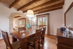 a dining room with a wooden table and chairs at Ecovilla ses oliveres by villasmediterranean in Llubí