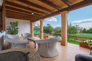 a patio with chairs and a table and a view at Ecovilla ses oliveres by villasmediterranean in Llubí