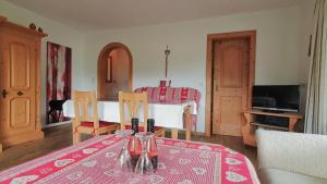a living room with a table with a red table cloth at Haus Bergliebe Kleinwalsertal in Riezlern