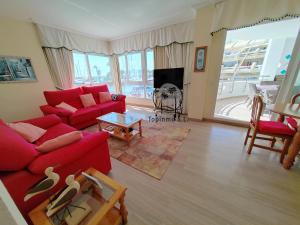 - un salon avec un canapé rouge et une table dans l'établissement Cozy corner 2 bedroom apartment on new Island complex in marina harbour, à Benalmádena
