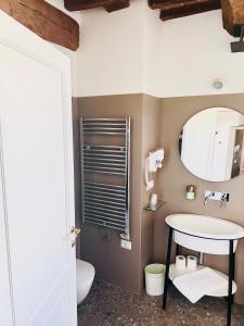 W łazience znajduje się umywalka i lustro. w obiekcie Guest House w mieście Campagnatico