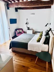 um quarto com uma cama grande e uma cadeira em Guest House em Campagnatico