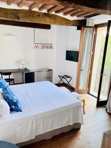 um quarto com uma cama branca e uma grande janela em Guest House em Campagnatico