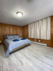 1 dormitorio con 1 cama grande y paredes de madera en Mexico Point Ranch, en Mexico