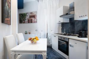 una cocina con una mesa con un bol de fruta. en Residenza Elisabetta, en Verona