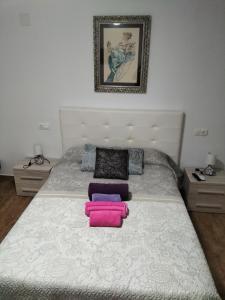 a bedroom with a bed with two pink pillows at LA POSAINA in Serradilla