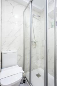 biała łazienka z prysznicem i toaletą w obiekcie El Ancla de Bermeo By Urdaibai Rentals w mieście Bermeo