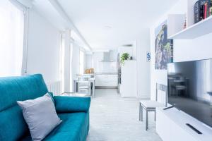 salon z niebieską kanapą i kuchnią w obiekcie El Ancla de Bermeo By Urdaibai Rentals w mieście Bermeo