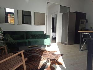 a living room with a green couch and a kitchen at Colon 13 in Zamora