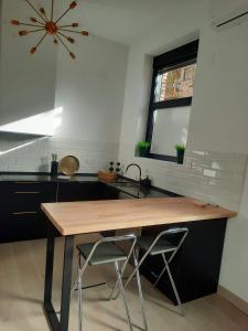 uma cozinha com uma mesa de madeira e um lavatório em Colon 13 em Zamora
