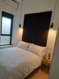 a bedroom with a large white bed with a black headboard at Colon 13 in Zamora