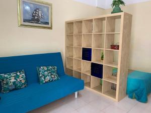 sala de estar con sofá azul y estante para libros en Appartamento Azzurra en Lecce