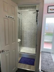a bathroom with a shower with a glass door at "The Parlour" Seafront Apartment in Eastbourne