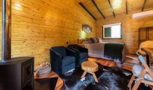 a room with a bedroom and a bed and a tv at Refúgio Urubici Chalé Boutique in Urubici