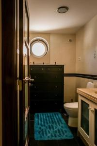 łazienka z toaletą i niebieską matą na podłodze w obiekcie Villa Ramiro w mieście Azeitão
