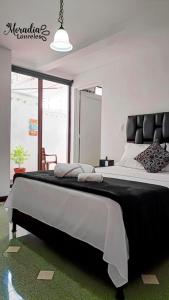 a bedroom with a large bed with a black headboard at Moradia Laureles Medellin in Medellín