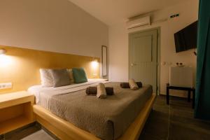 een slaapkamer met een bed met twee handdoeken erop bij White Element in Karterados