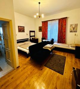 uma sala de estar com um sofá e uma cama em Kis Gellért Guesthouse em Budapeste