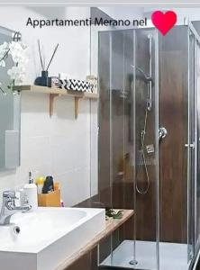 ein Bad mit einer Dusche und einem Waschbecken in der Unterkunft Appartamento Merano nel cuore in Meran