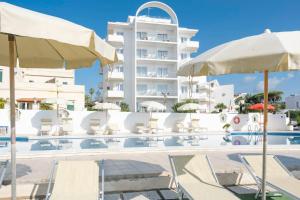 a pool with chairs and umbrellas and a building at Residence Cavalluccio Marino in Santa Marinella