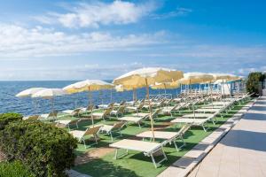 una fila de sillas y sombrillas en una playa en Residence Cavalluccio Marino, en Santa Marinella