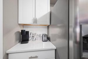 a kitchen with white cabinets and a refrigerator at Hadley's Place at Pointe Royale, Pristine 2 Bed 2 Bath Condo in Branson