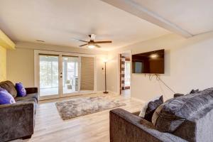 a living room with two couches and a ceiling fan at Lakefront Vacation Rental with Dock and Views! in Camdenton