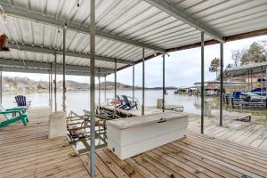 a wooden dock with a boat in the water at Lakefront Vacation Rental with Dock and Views! in Camdenton