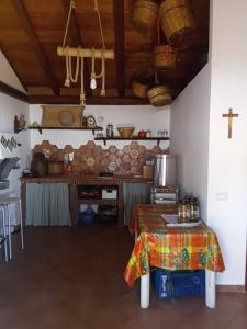 una cocina con una mesa y una cruz en la pared en La dependance Etna, en Biancavilla