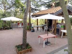 un patio con mesas y sombrillas en La dependance Etna, en Biancavilla
