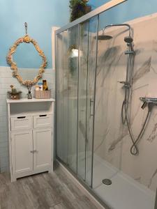 een badkamer met een douche en een glazen douchecabine bij Le Finestre sul Mare in Albissola Marina