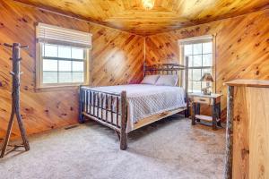 una camera con un letto in una cabina di legno di Racine Vacation Rental 25 Mi to Athens! a Racine