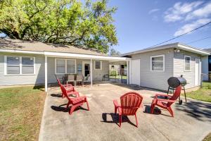a patio with red chairs and a grill in front of a house at Coastal Long Beach Rental with Patio, Walk to Beach! in Long Beach